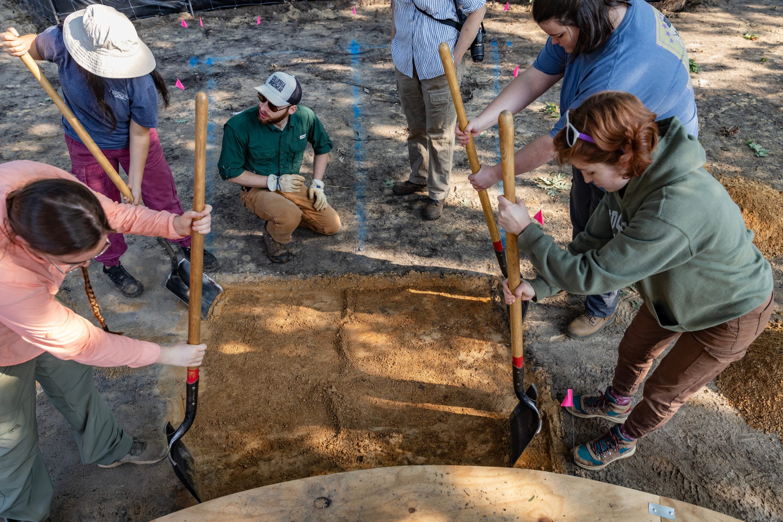 Students from UNC-Chapel Hill check the area around the Old Well for historic artifacts.