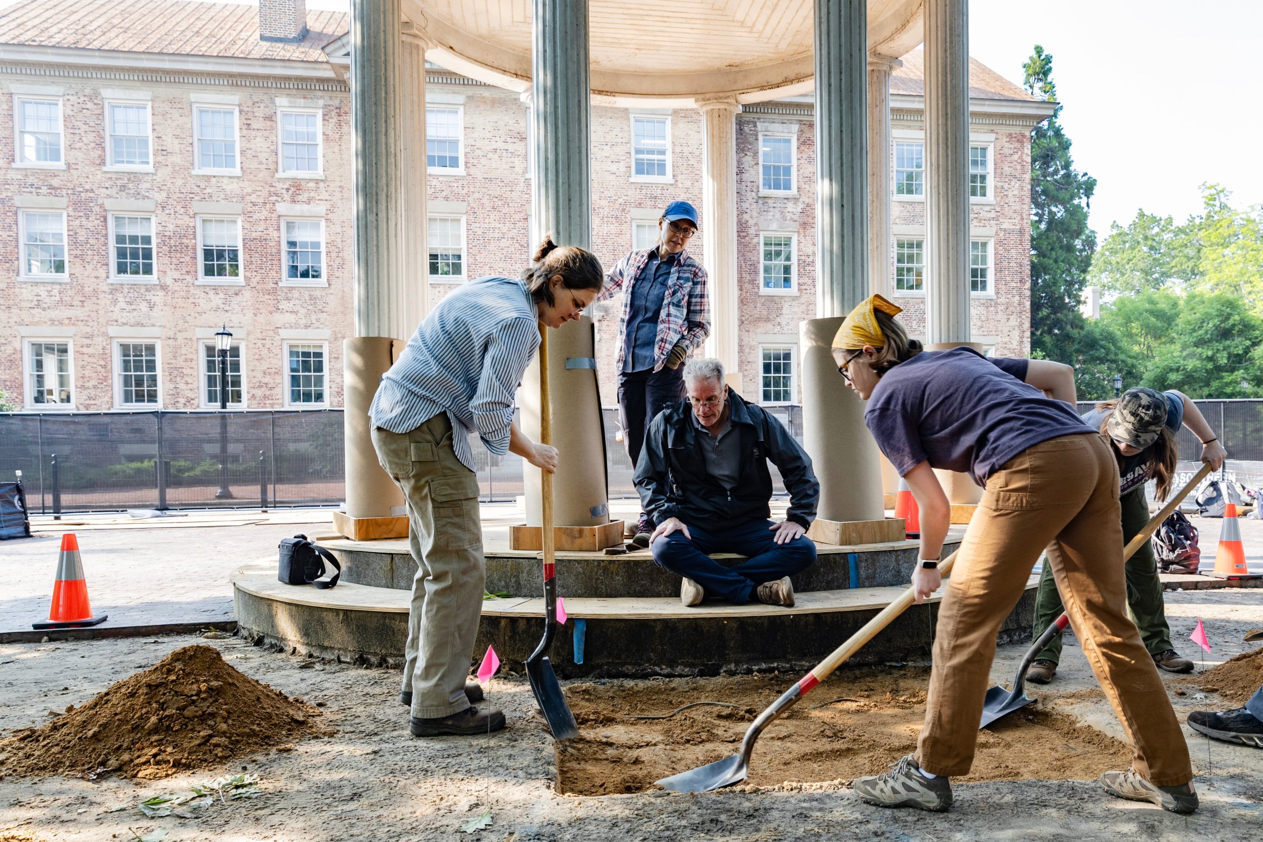 Students from UNC-Chapel Hill check the area around the Old Well for historic artifacts.